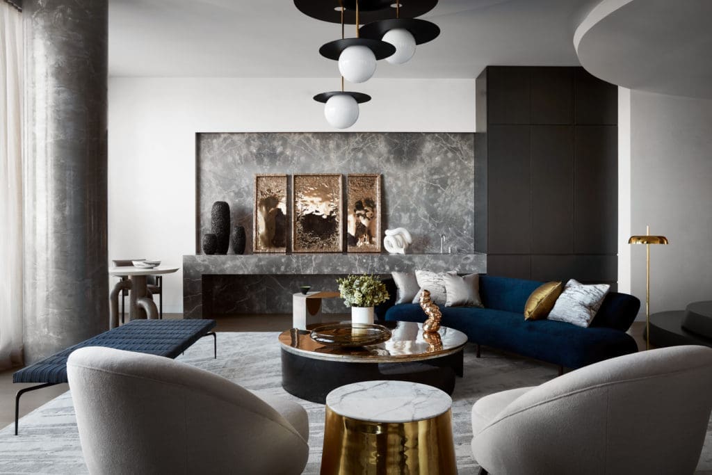 The sensuous furniture in this full-floor Tribeca aerie designed by Drake/Anderson reiterates recurring motifs. On the back wall, a gray stone inset and counter incorporate a wet bar. (Photo by Stephen Kent Johnson)