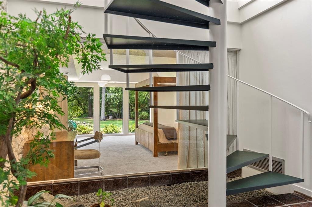 The spiral staircase encased in an atrium overlooks the primary bedroom at 503 Timber Terrace Road. (Photo by Nan Studios)