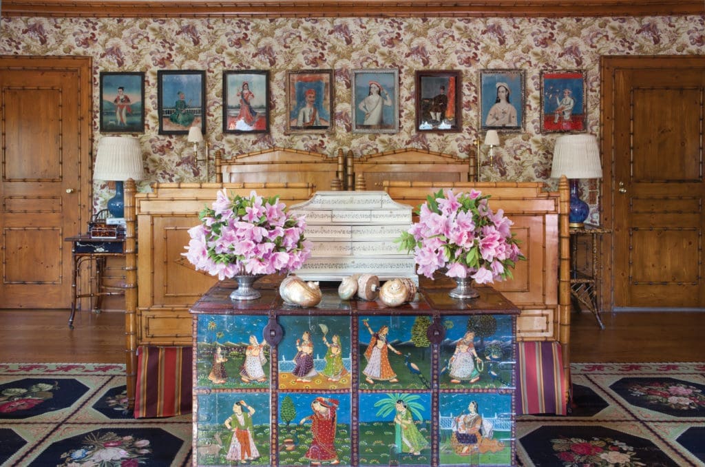A "bamboo" guest room reflects Ann Getty's enduring love for traditional Indian decorative arts and Anglo-Indian craftsmanship. Front and center is a fine example of the art of Mughal India, a 19th-century painted padouk wood chest that depicts sari-clad women and peacocks in palace gardens. Walls are covered with Rosemount cotton by Marvic, London. (Photography by Lisa Romerein)