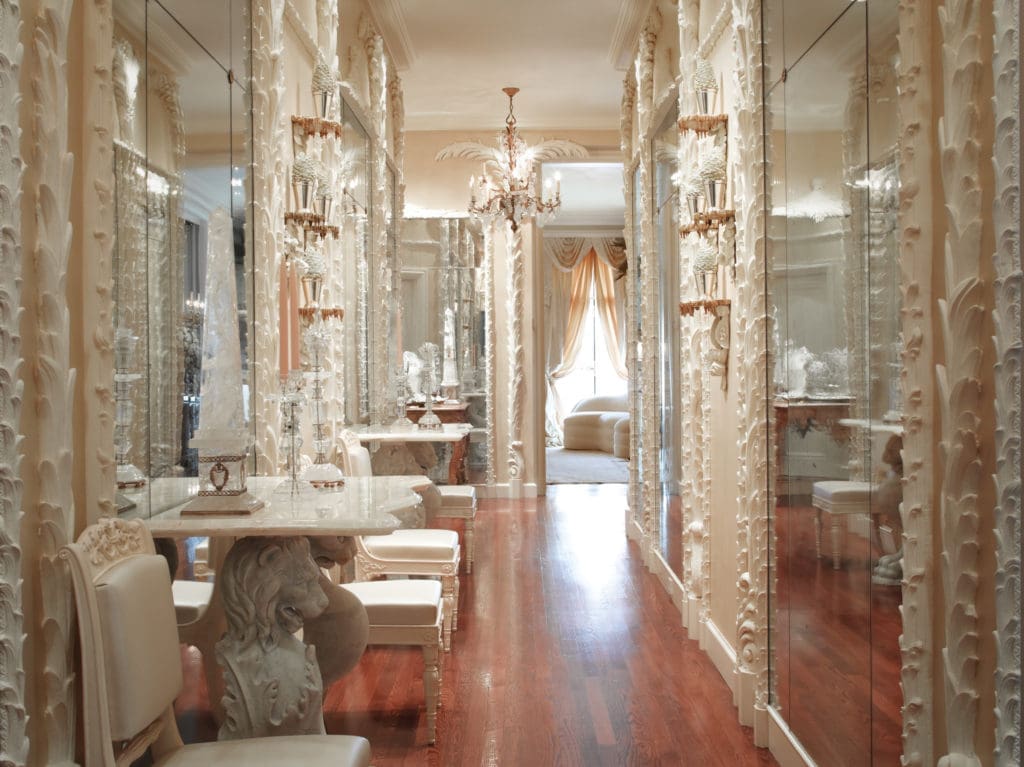Ann Getty worked with San Francisco antiques dealer Terry Gross to plan the elaborate mirrored hallway of Gross's Nob Hill apartment as a subtle homage to the Hall of Mirrors, the dazzling feature of the Château de Versailles. It's also a nod to California interior designer Frances Elkins, another Francophile, who first introduced the chic plaster palmier columns and torchières of 1920s Paris designer Serge Roche to her clients. These hallway moldings were created in white plaster from original Régence models by Féau & Cie. (Photography by Lisa Romerein)