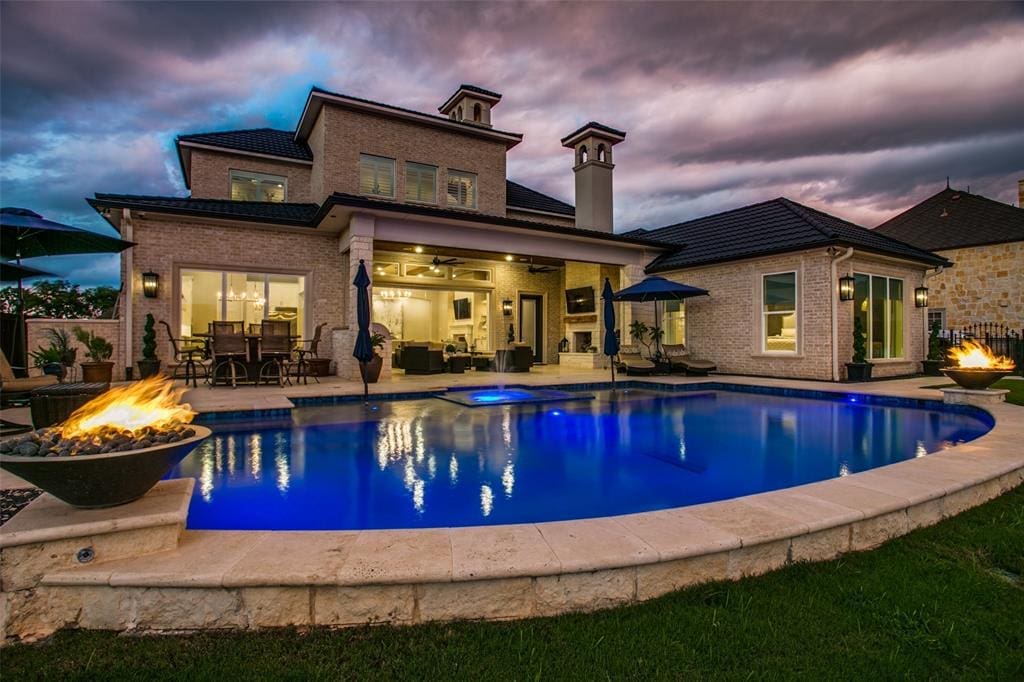 Outdoors is an oasis at 6025 Lakeside Drive, with a dramatic pool, fire urns and a water feature.