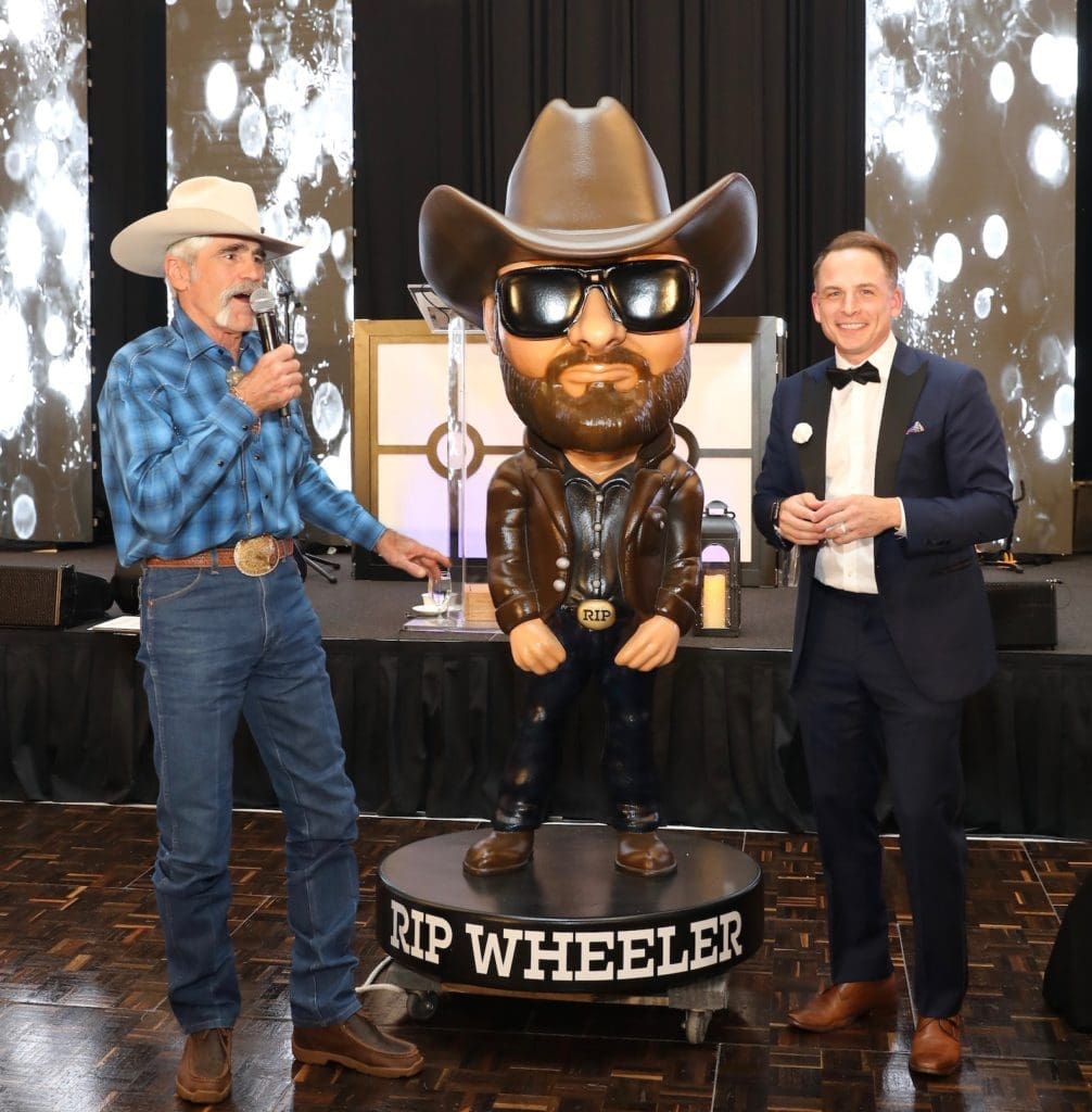 Forrie J. Smith, auctioneer Johnny Bravo with the Cole Hauser bobble-head at the Houston PetSet 'Fierce & Fabulous Soirée' (Photo by Priscilla Dickson)