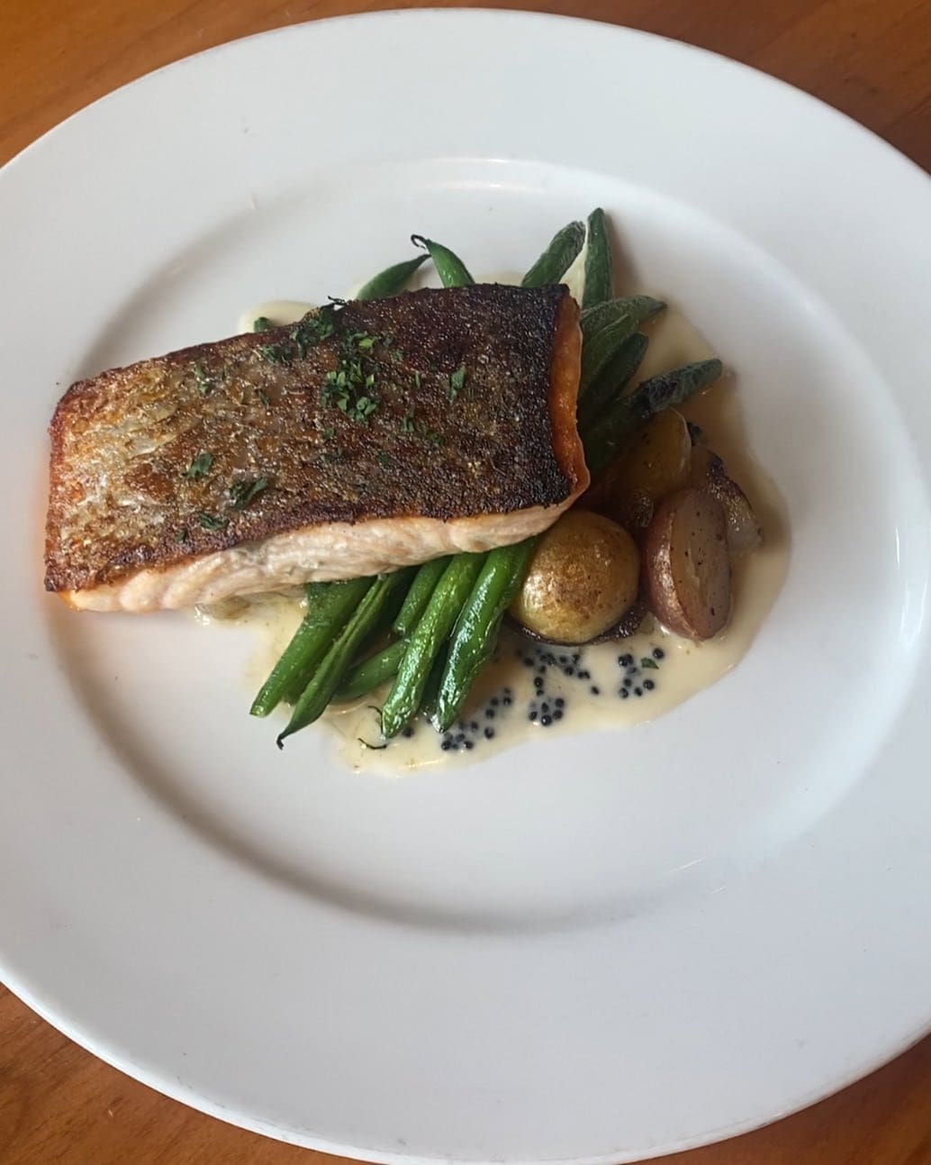 A recent salmon dish from the new Wallon's sister restaurant Clay Pigeon featured green beans, marble potatoes, Cipollini onions and a decadent caviar beurre blanc.