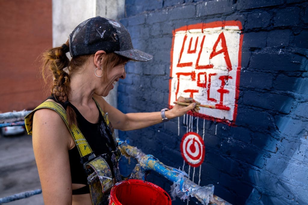Artist Lola Goce paints her signature on her mural. (Photo by @superkant and @cyvisuals_, courtesy Street Art for Mankind)