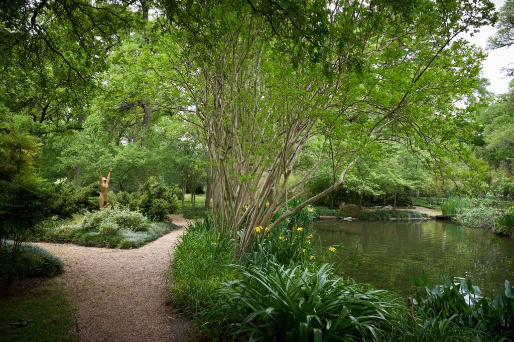 At far right, a Japanese bridge crosses over the pond. The  pickerel weed at lower right was a gift from artist David Gibson. (Photo by Pär Bengtsson / art direction by Michelle Aviña)
