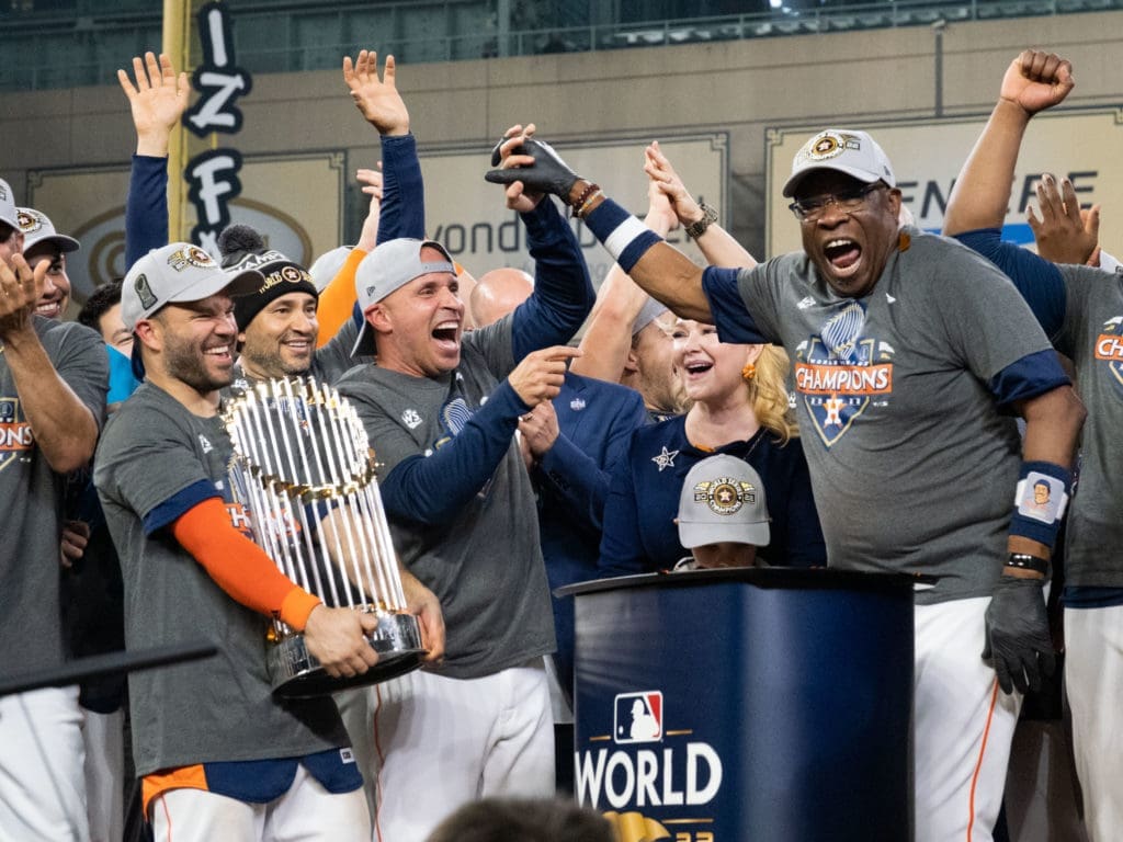 Jose Altuve could only smile at how happy manager Dusty Baker was. And continue to hug that trophy. (Photo by F. Carter Smith)