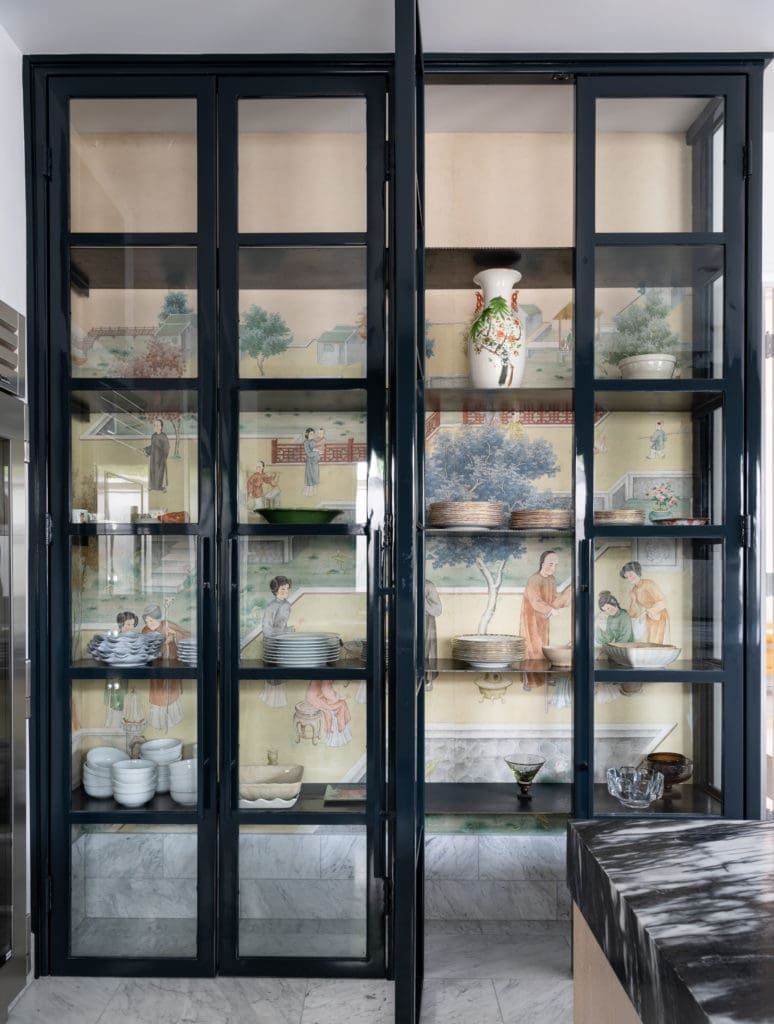 The custom iron China cabinet is backed by salvaged antique Japanese wallpaper in the kitchen. Photo by Michael Hunter