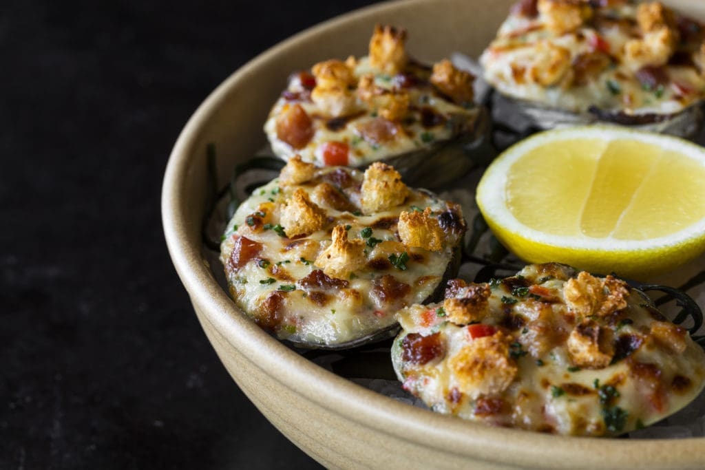 Clams casino is served at the seafood centered restaurant, Navy Blue. (Photo by Julie Soefer)