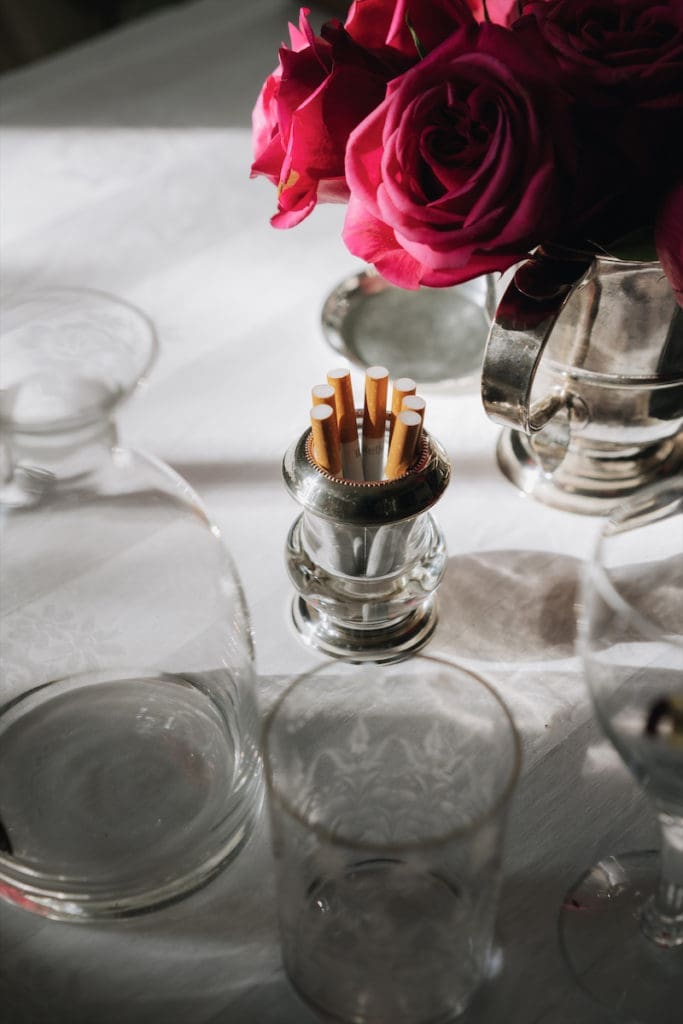 The table is always set with individual vases of Marlboro cigarettes, as her mother did in the ’60s. (Photo by Afritina Coker)