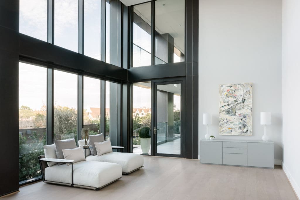 The main floor primary bedroom of the CASA Companies' condo enjoys two stories high windows facing north. (Photo by Divya Pande)