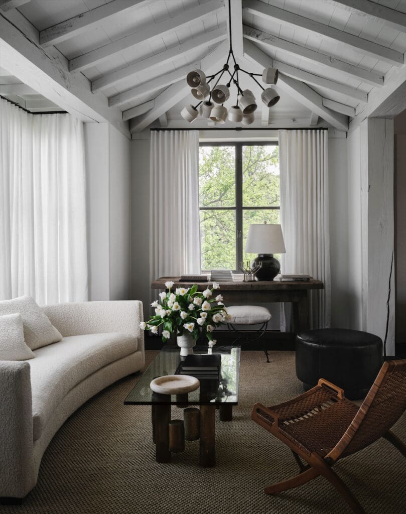 A sitting area off the primary bedroom with a sofa in Kravet bouclé, Materia Forchette chandelier, Brutalist coffee table, and desk that Dorsey discovered at Round Top. (Photo by Douglas Friedman)