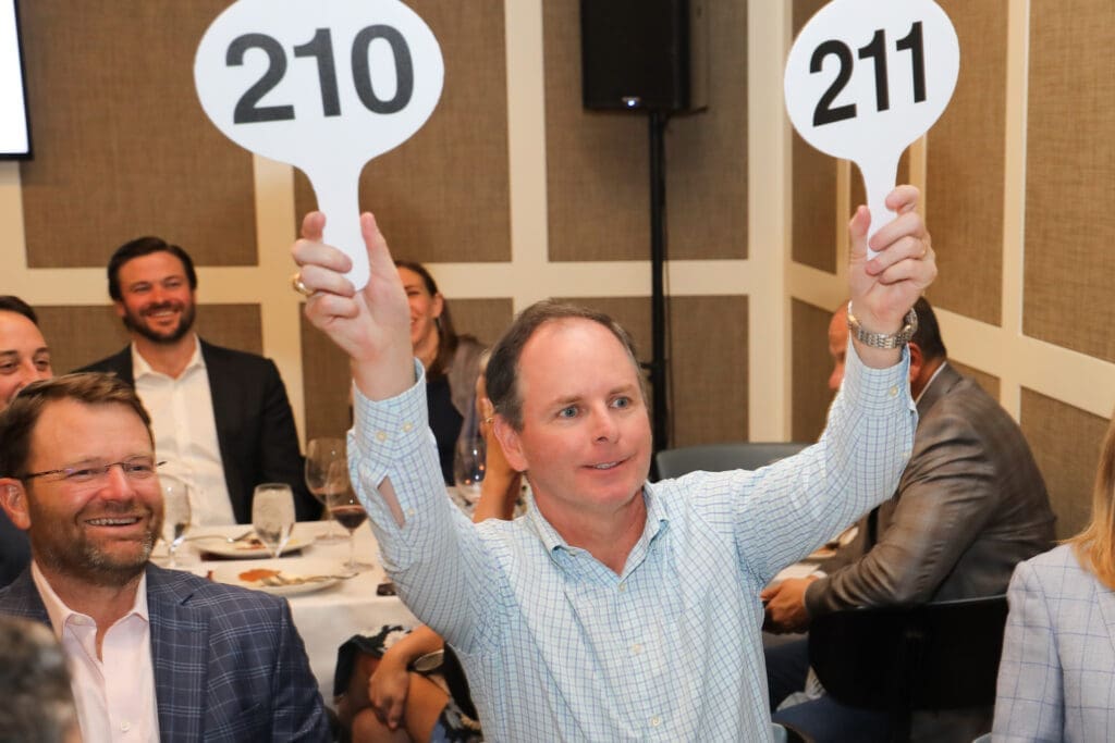 Double-handed bidding at the Houston Classical Charter School Foundational Dinner (Photo by Priscilla Dickson)