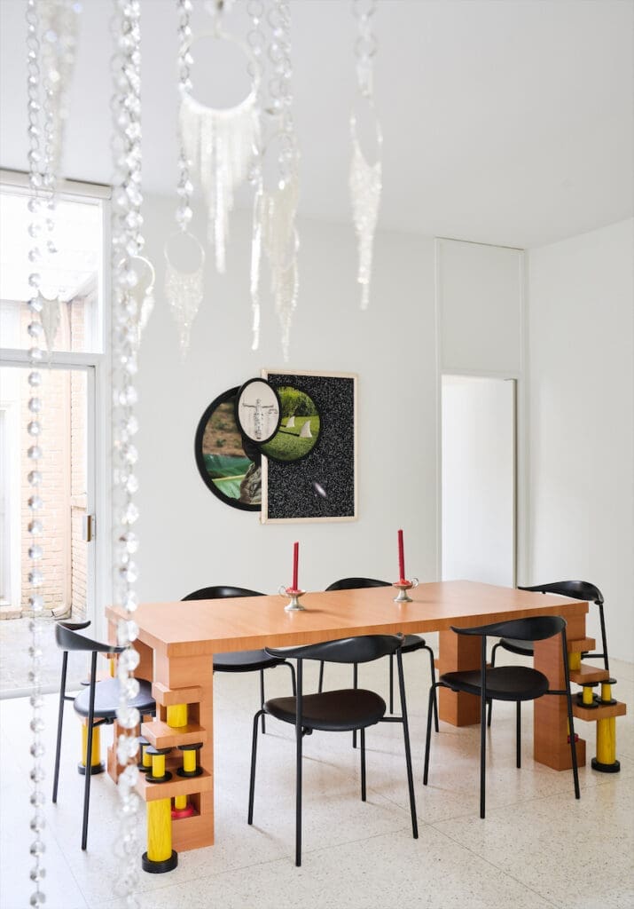 In the dining room, a Memphis table by Ettore Sottsass and Hans Wegner chairs. Photo-based artwork by Todd Gray. Kayode Ojo chandelier sculpture. (Photo by Jack Thompson)