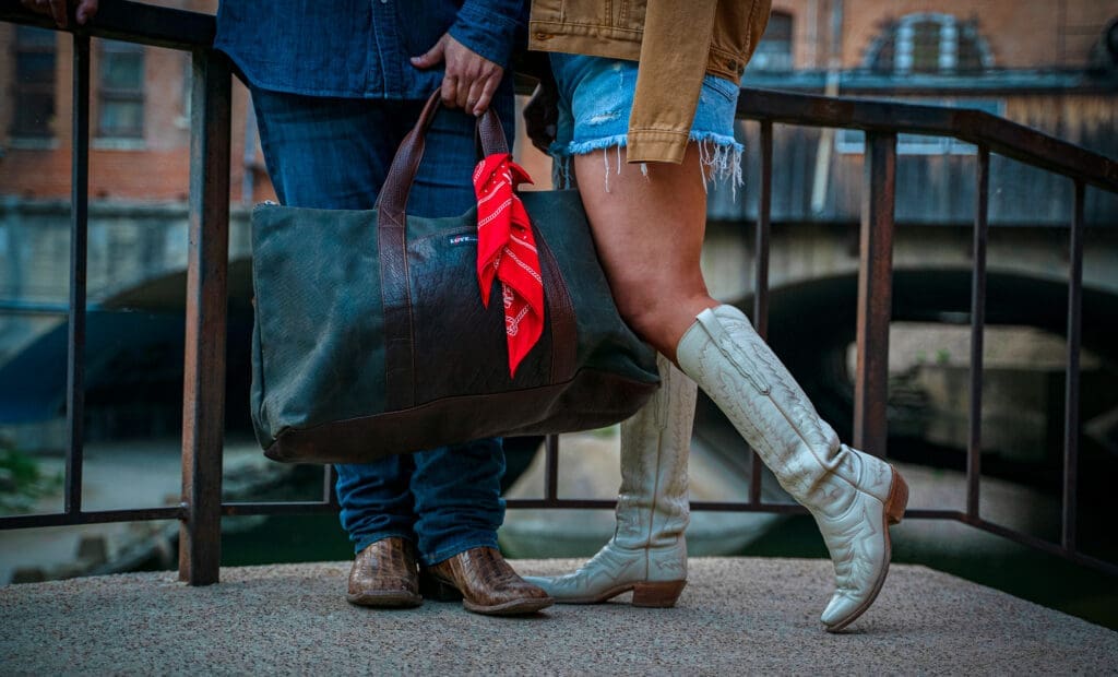 Denim shirt, men's dark boot cut jean, canvas trucker jacket, weekender bag, and red bandana. (Photo by Daniel Hooks)