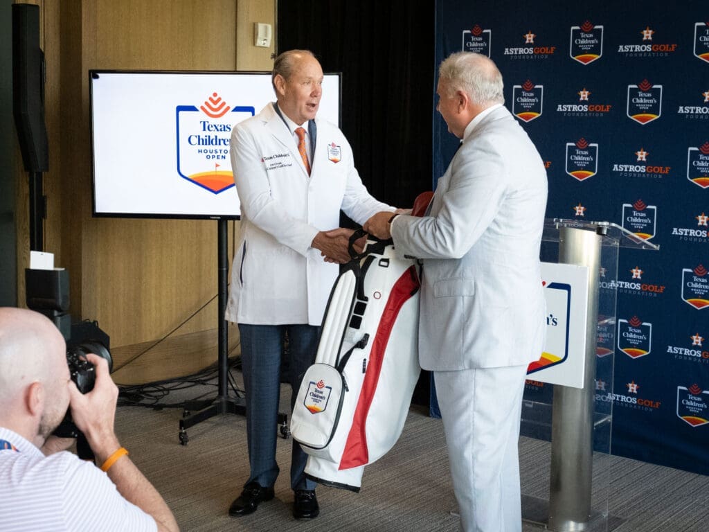 Jim Crane received a Texas Children's doctor's coat and Mark Wallace was gifted a Texas Children's Houston Open golf bag.  (Photo by F. Carter Smith)