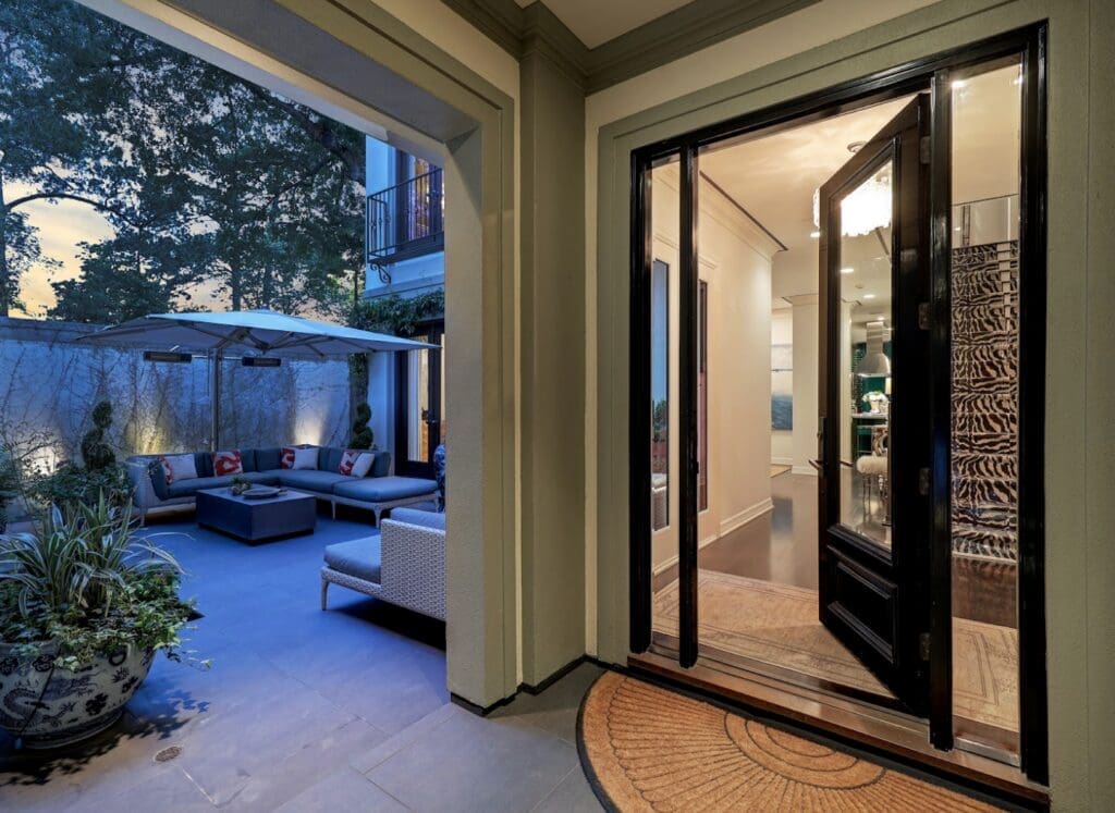Glass doors open to the interior courtyard The turquoise kitchen in the luxurious 'Tuscan Villa' townhome at 5722 Logan Lane (Photo by TK Images/Compass)
