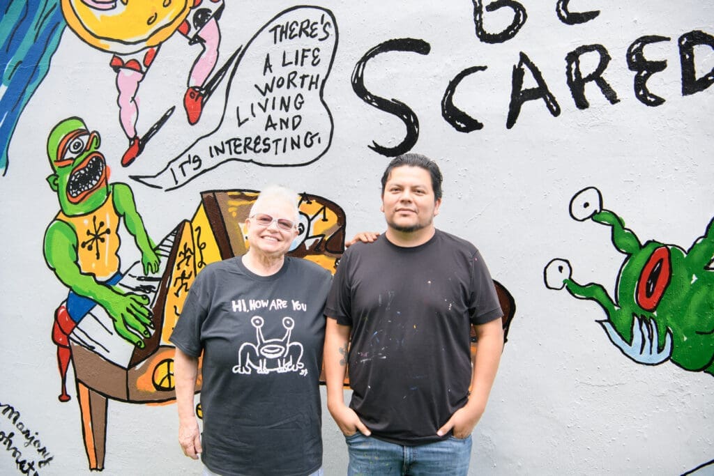 Marjory Johnston, artist Carlos Alcaraz (Empyre) at the "Don't Be Scared" mural  at Redbud Arts Center (Photo by Saranna Zhang/Kevin Zhang Photography)