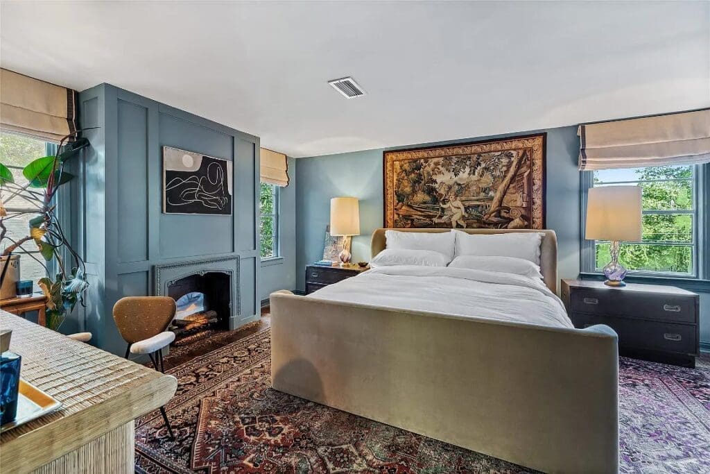 The primary bedroom features a fireplace and plenty of natural light. 