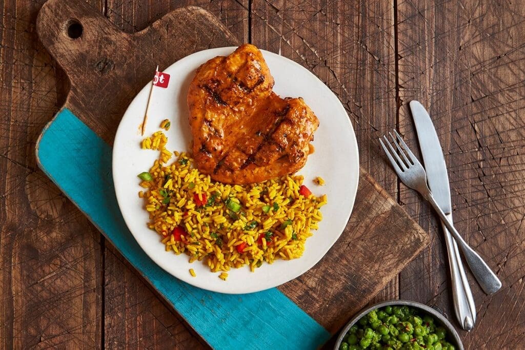 Nando's is known for its flame-grilled chicken. Pictured here is the  butterfly chicken breast with Portuguese Rice and macho peas. (Photo by Greg Powers)