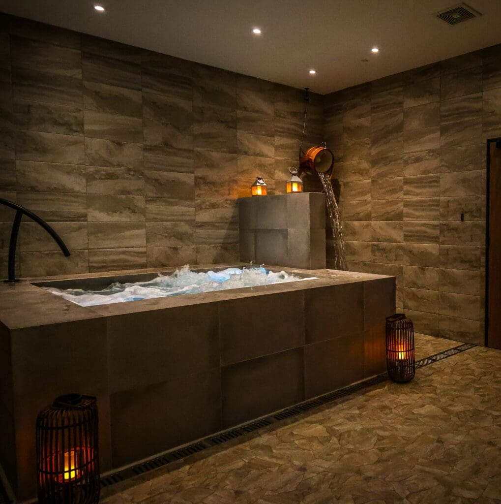Resort-style amenities include the complimentary coed wet room. There, guests can soak and unwind those tense muscles in a bubbling 12-person hot tub, step into the eucalyptus-scented steam-filled dry sauna, then jump from hot to cold and experience a refreshing splash of contrast bathing with a simple pull of a rope. (Photo by Courtesy of Escape Spa)