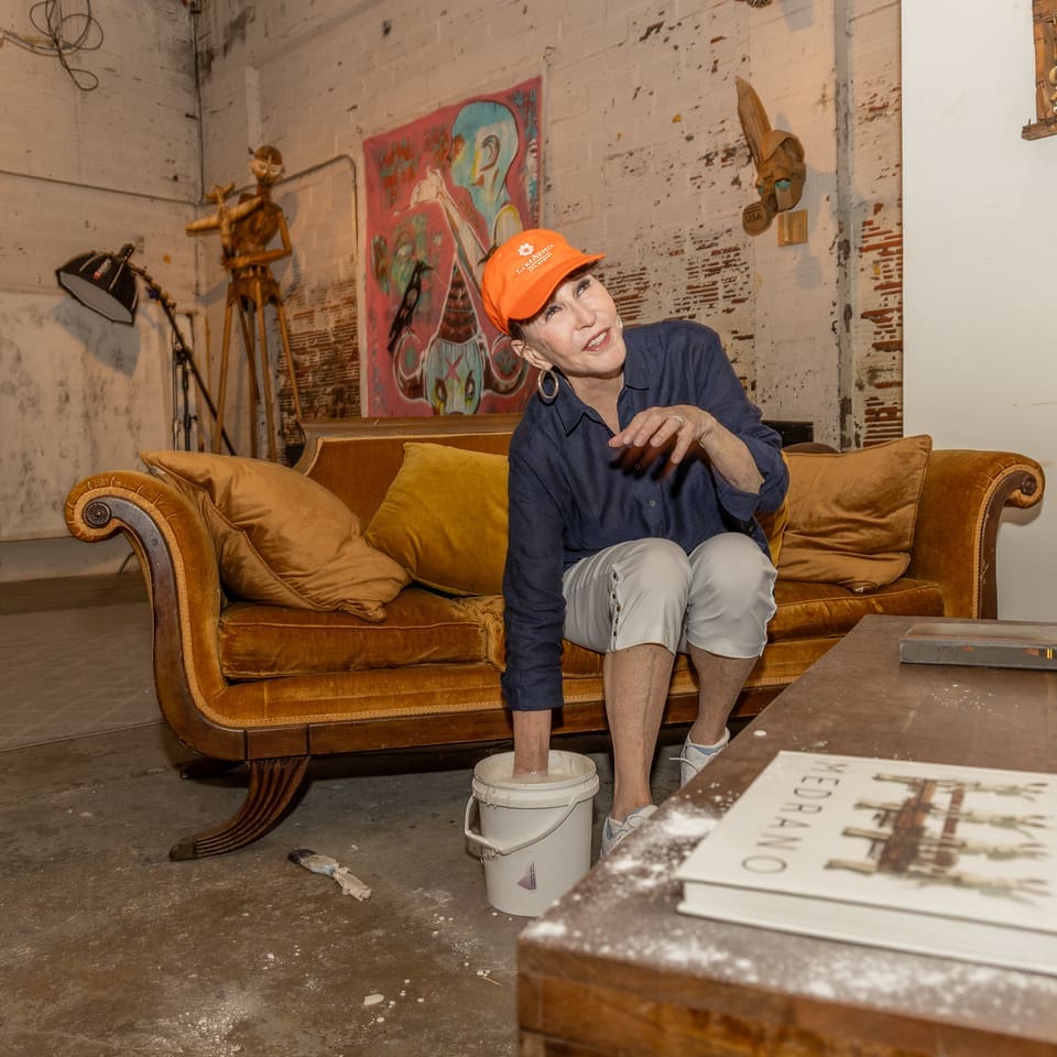 Shelby Hodge is a good sport dipping her hand into a bucket of silicone rubber in the name of art. (Photo by Katy Anderson)
