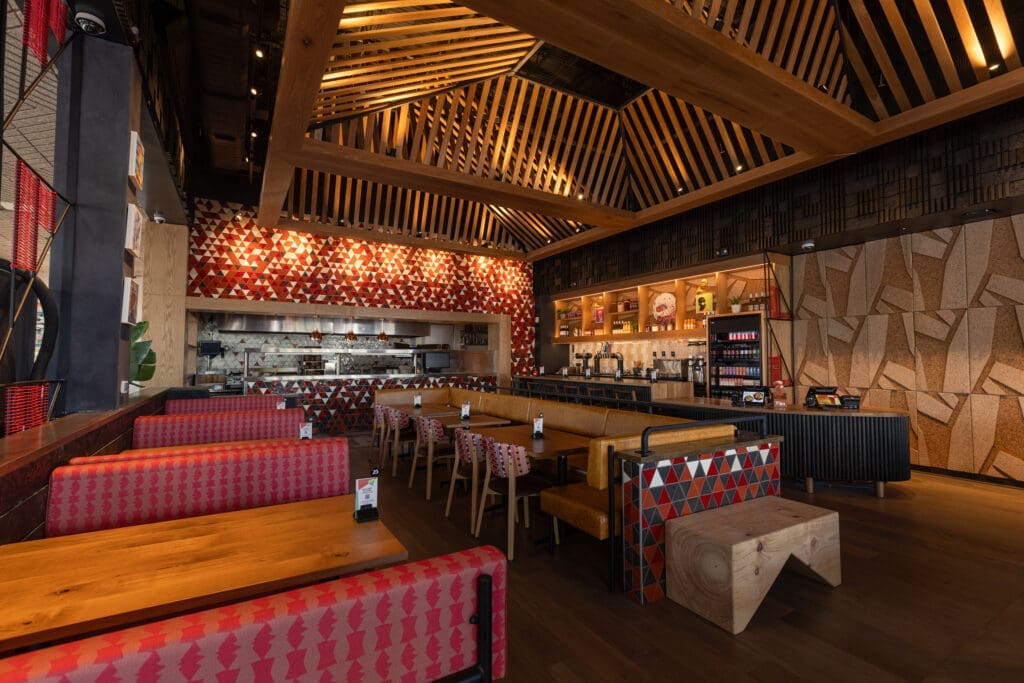 The rapidly expanding brand tapped Texas-based Michael Hsu Office of Architecture to conjure the vibrant space with soaring ceilings replete with a modern structural take on a traditional thatched roof built inside the dining room. Photo by Michael Anthony