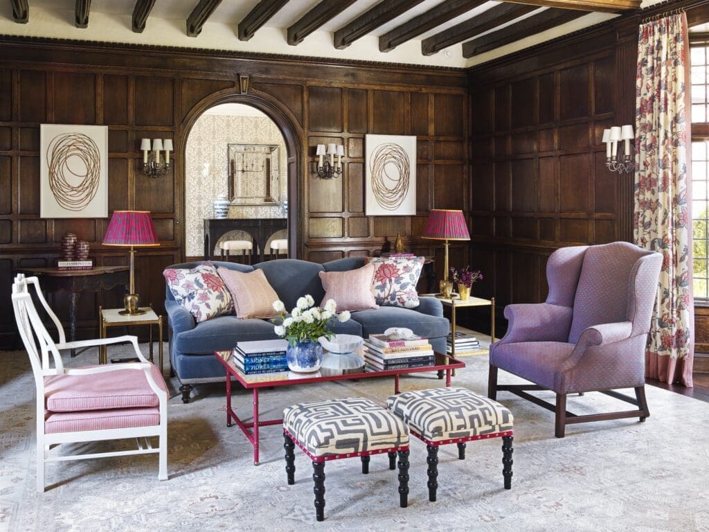 Traditional shapes and forms enlivened with bright, bold colors and patterns make an impact within dark oak surroundings, in a room designed by Carrier and Company. The oversize antique Chippendale chair
stands out in its updated lacquer finish. Artwork flanking the doorway is by Neal Perbix. (Photo by Annie Schlechter) 