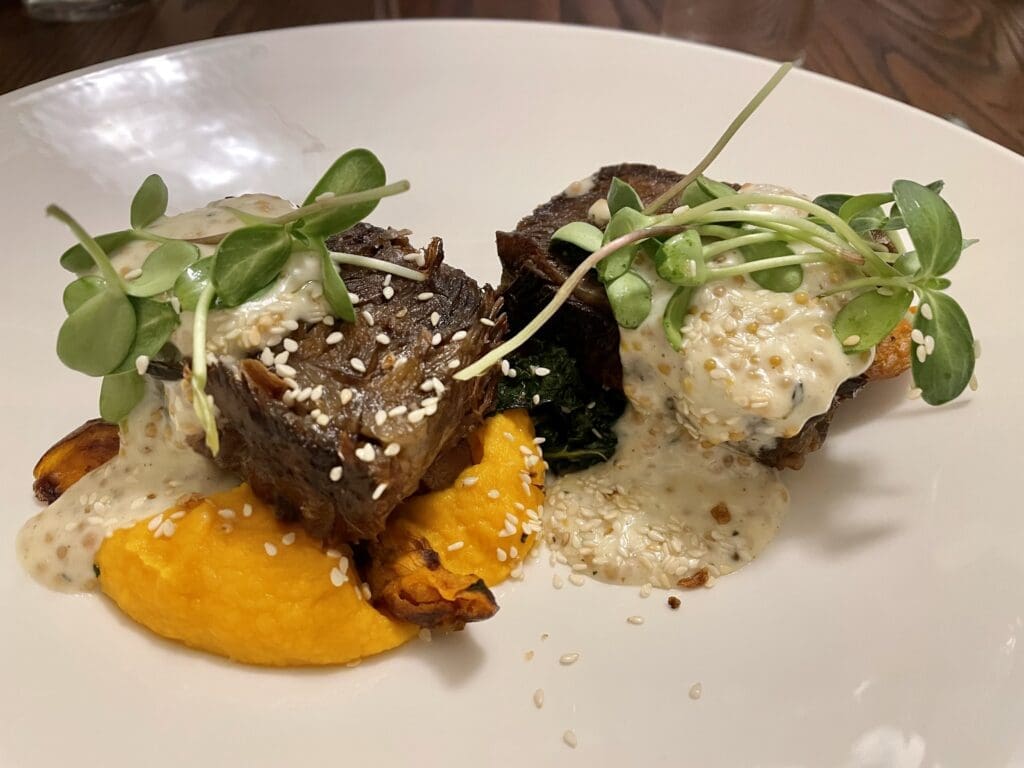 Beef short rib draped with both a sesame garlic crumble as well as a punchy pickled mustard butter sauce. (Photo by Courtney Dabney)