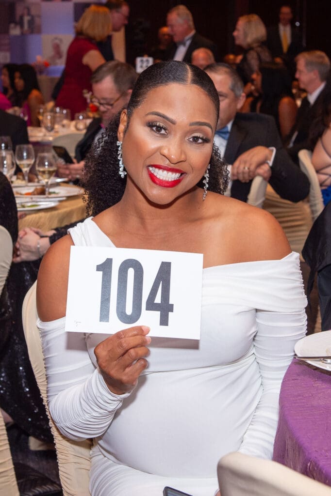 Jamila Ryans, wife of Houston Texans coach DeMeco Ryans, makes a bid at the Linda Lorelle Scholarship Fund 'Paying It Forward' gala. (Photo by Jacob Power)