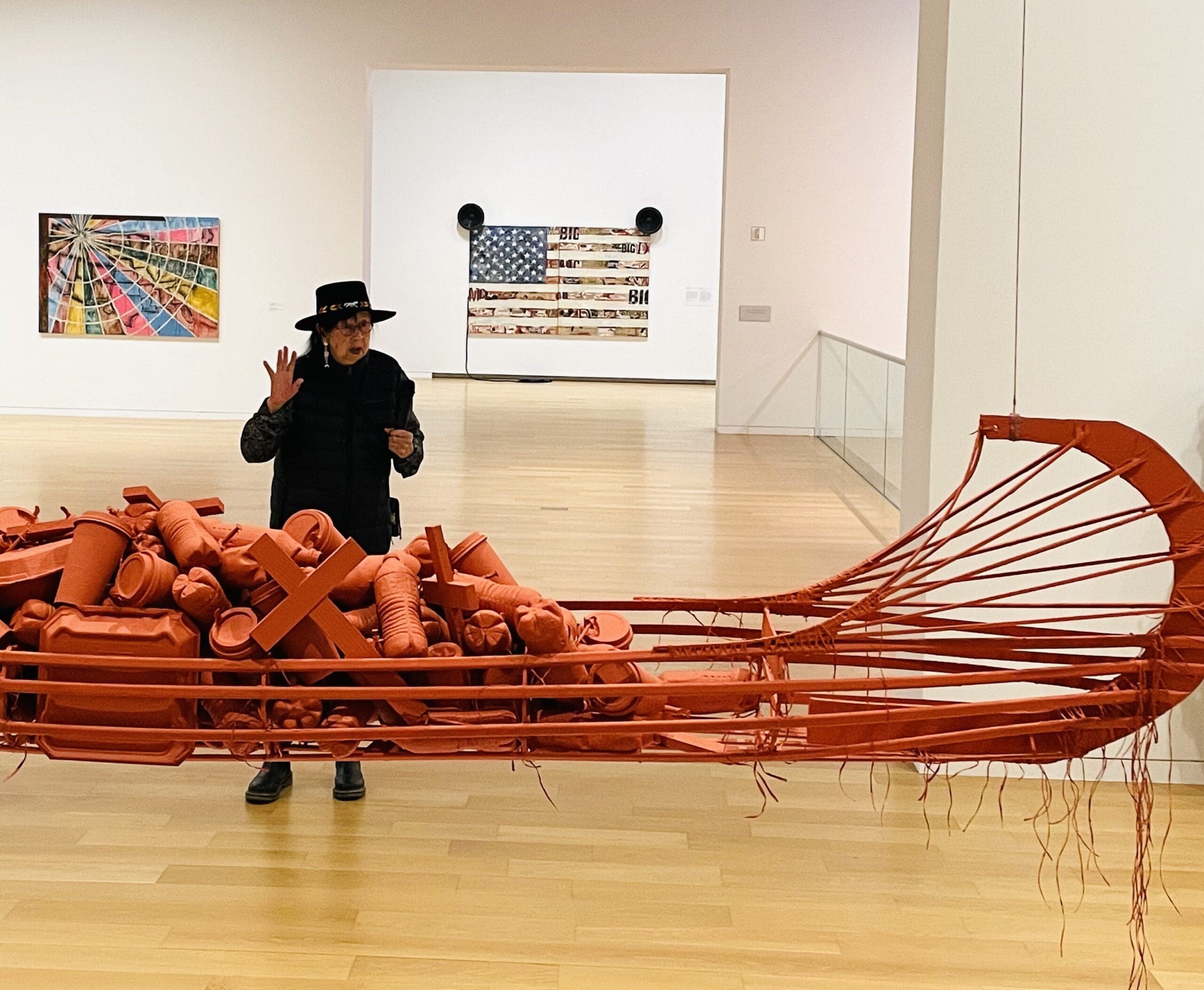 The artist explains the meaning of the red ochre colored canoe sculpture. (Photo by Courtney Dabney)