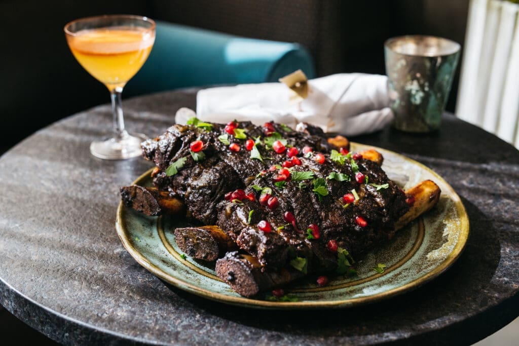 The three-bone short rib glazed with a pomegranate sauce ($145.00) serves three to four people at Rumi's Kitchen. (Courtesy of Rumi's Kitchen)