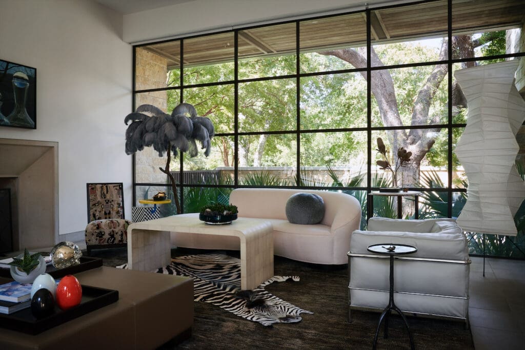 In the living room, the Vladimir Kagan sofa is vintage. Ironies' shagreen coffee table references an original by Jean-Michel Frank. The ostrich plume floor lamp, skull, and collection of eggs is from Grange Hall. A vintage Donghia chair is covered in Clarence House fabric with 1980s Memphis table by Ettore Sottsass.  (Photo by Pär Bengtsson)