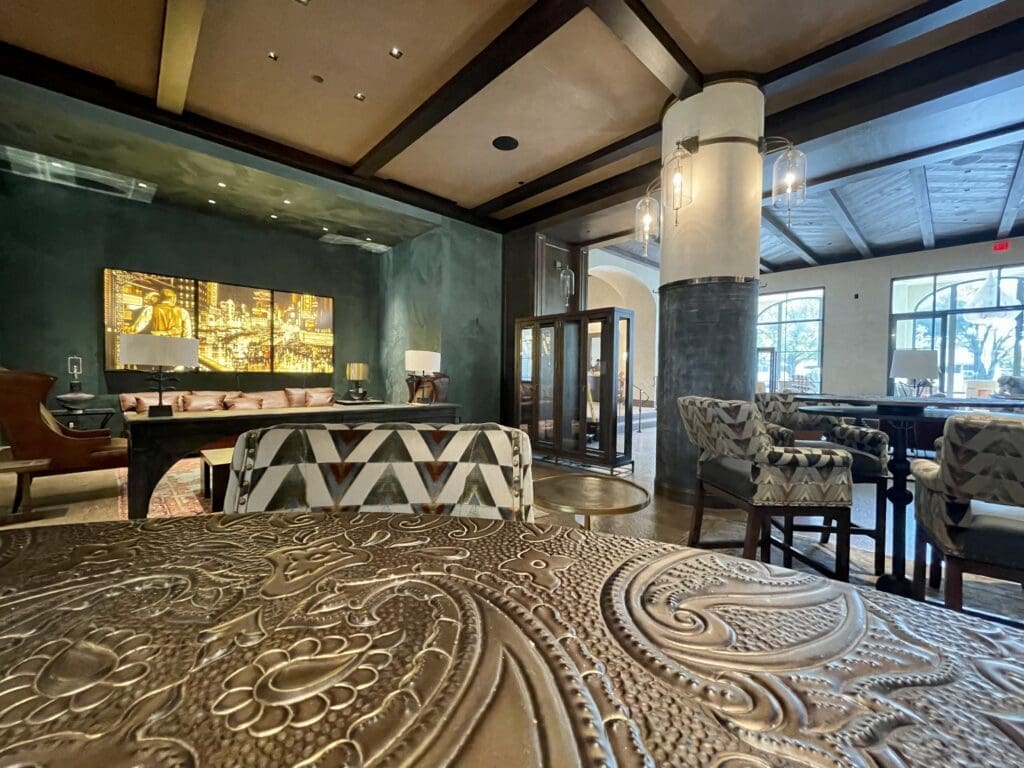 Table top with hand-tooled leather effect and Max Zorn artwork glowing in the background. (Photo by Courtney Dabney)