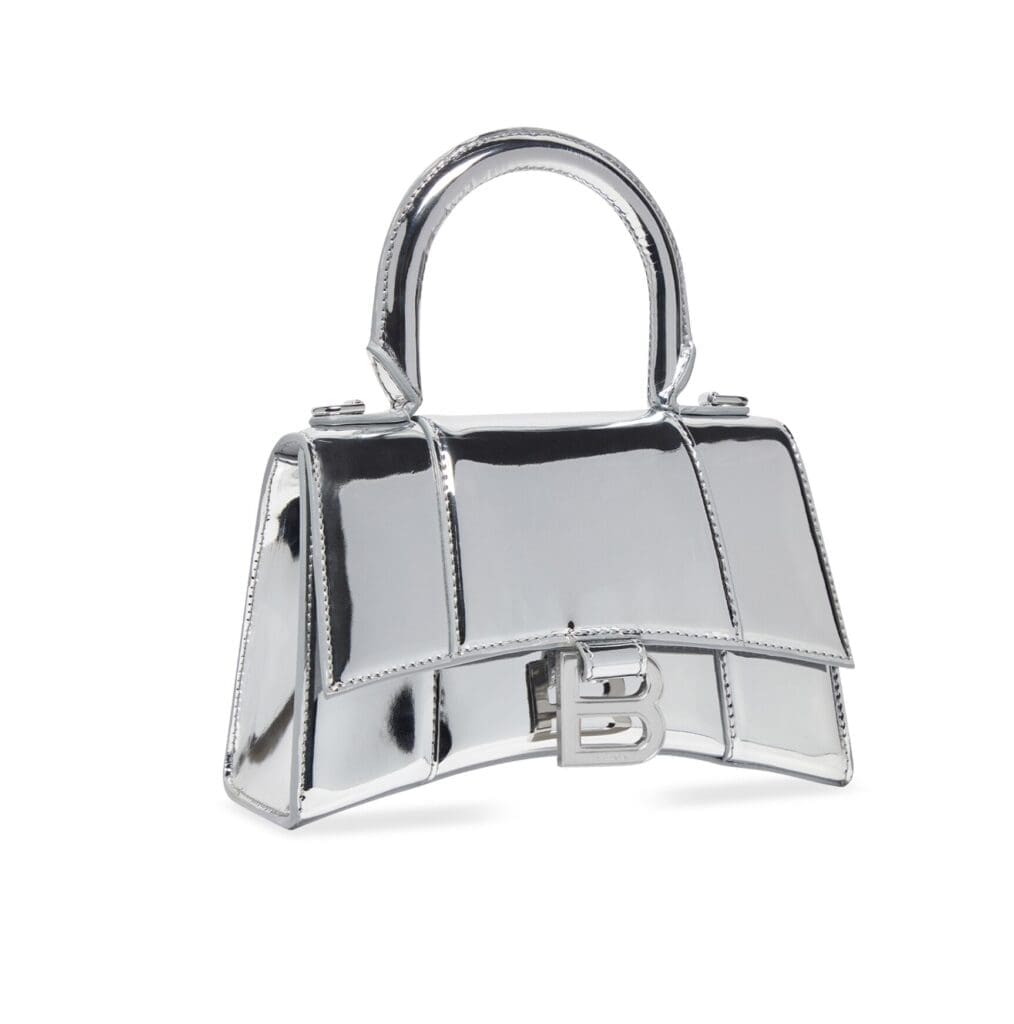 Balenciaga hourglass mirrored silver handbag with B logo.