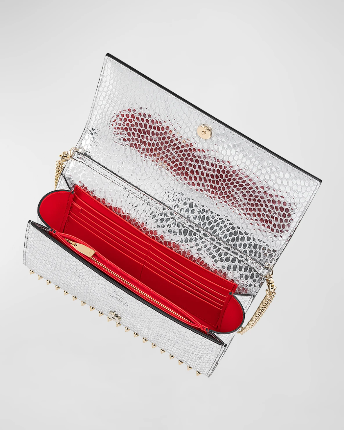 Christian Louboutin's Paloma spike metallic clutch with statement red interior.