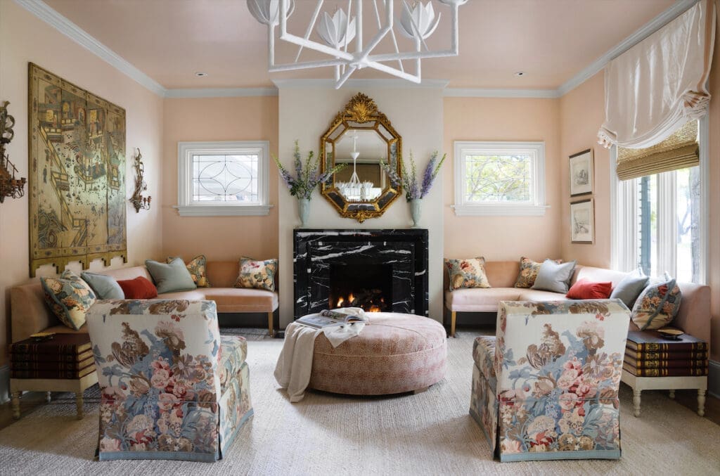Benjamin Moore Old Country pink living-room walls. Custom chairs by Kisabeth Furniture, upholstered in a historic 1926 floral block-print linen design by Hazelton House. Visual Comfort chandelier. (Photo by Emily Minton Redfield)