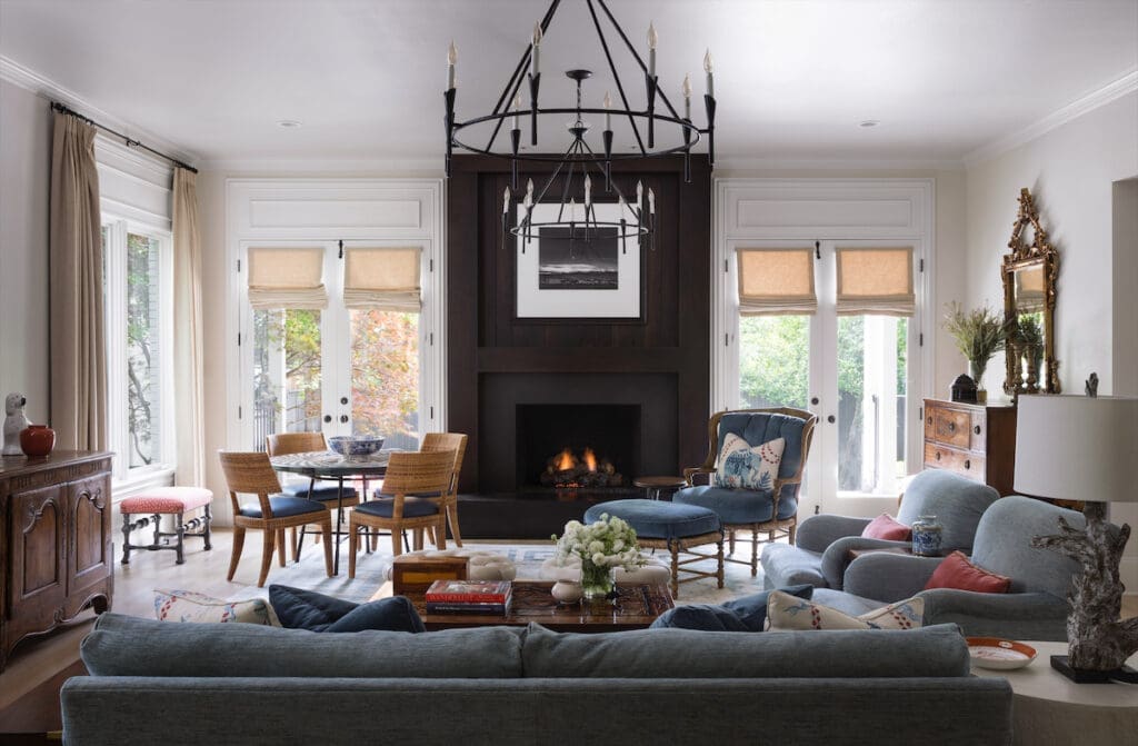 The family room’s fireplace is made from 100-year-old walnut. Photograph by Ansel Adams from David Arrington’s collection. Minton-Corley Collection game table, made in Italy. Rattan chairs from David Sutherland Showroom. Quackenbush armchair. Eighteenth-century English antique chest. Visual Comfort chandelier. (Photo by Emily Minton Redfield)