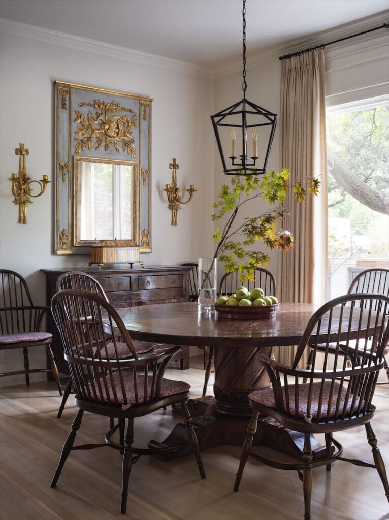 The breakfast room’s French trumeau mirror and English Windsor chairs are from Joseph Minton Antiques. The table is reproduction country French. Visual Comfort lantern. (Photo by Emily Minton Redfield)
