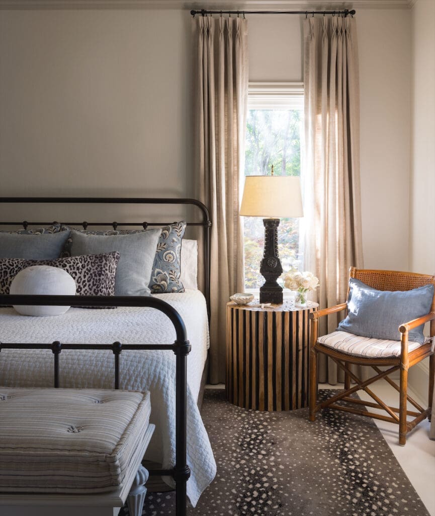 In the guest bedroom, a reproduction iron bed and McGuire rattan chair. Stark rug. (Photo by Emily Minton Redfield)
