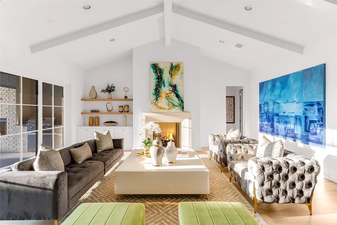 4648 Esprit – The great sun-filled great room with floating bookshelves, herringbone backed fireplace and entry to the primary suite to your right