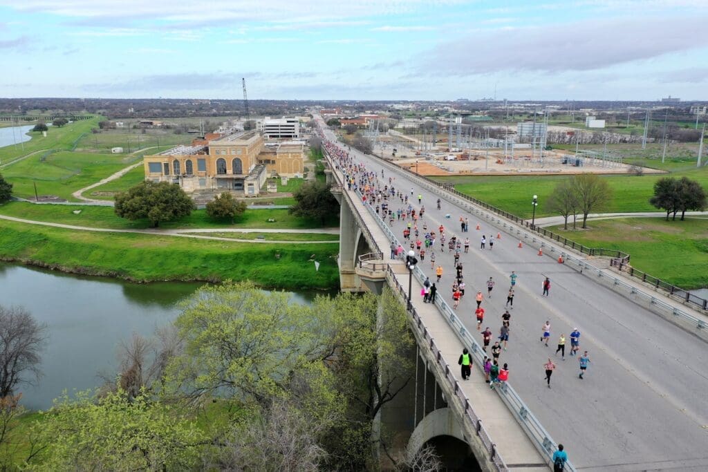 Photo of runners traversing the Northside bridge during the Cowtown Marathon. (Photo by Brian Luenser)