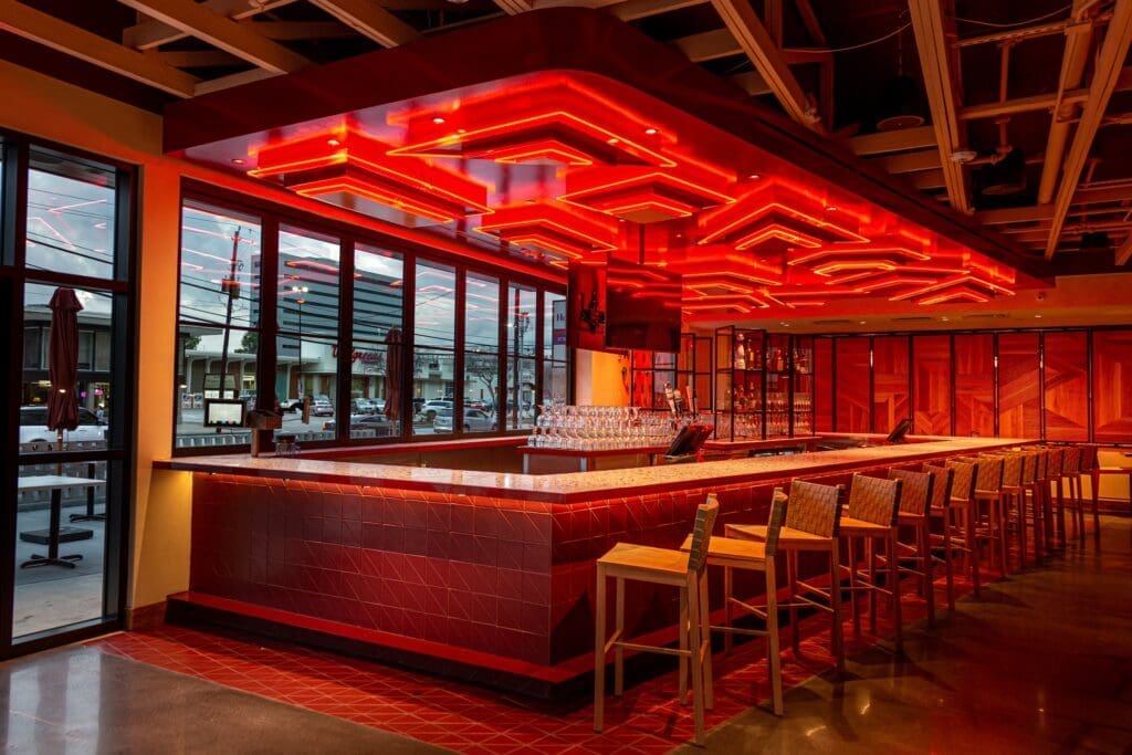 The dynamic bar area at the new Cyclone Anaya's River Oaks features angular geometry built into a suspended canopy, illuminating the area with brightly painted triangular tiers highlighted with neon bands. (Photo by Jenn Duncan)