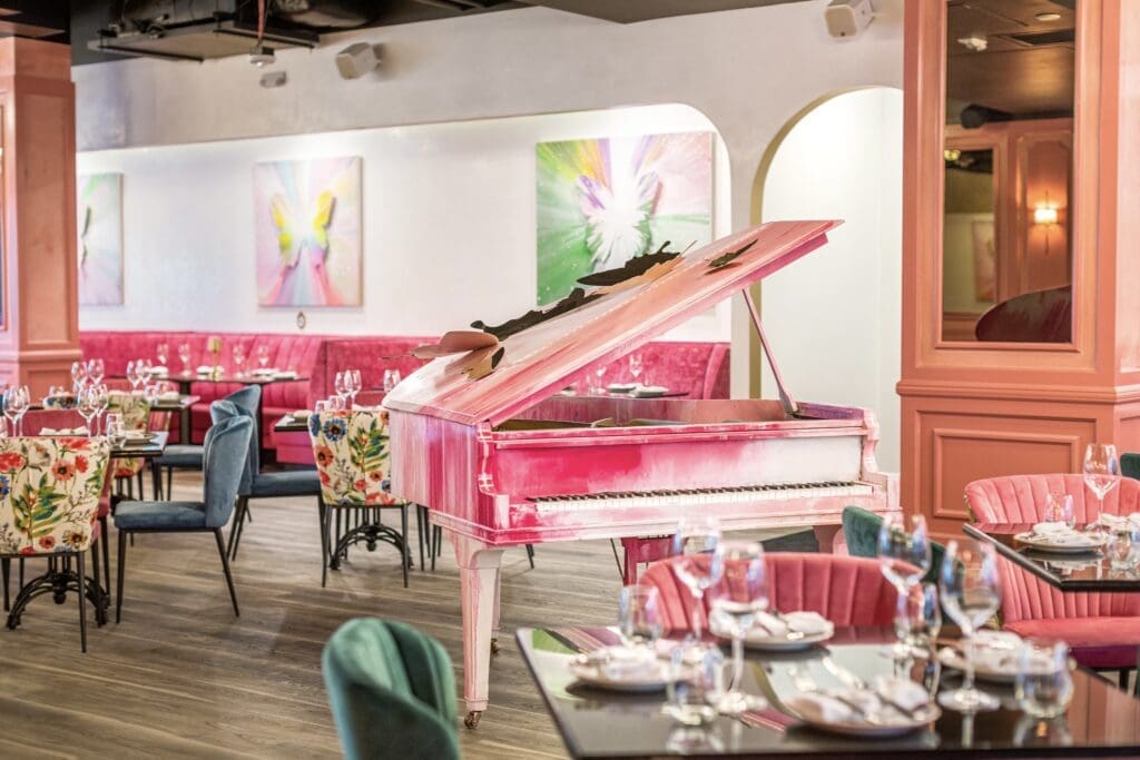 A hand-painted pink grand piano at Post Script was created by artist Roman Lefebvre who also created the butterflies festooning the exterior of the building, the former stead of Del Frisco's Grille. (Photo by Jenn Duncan)