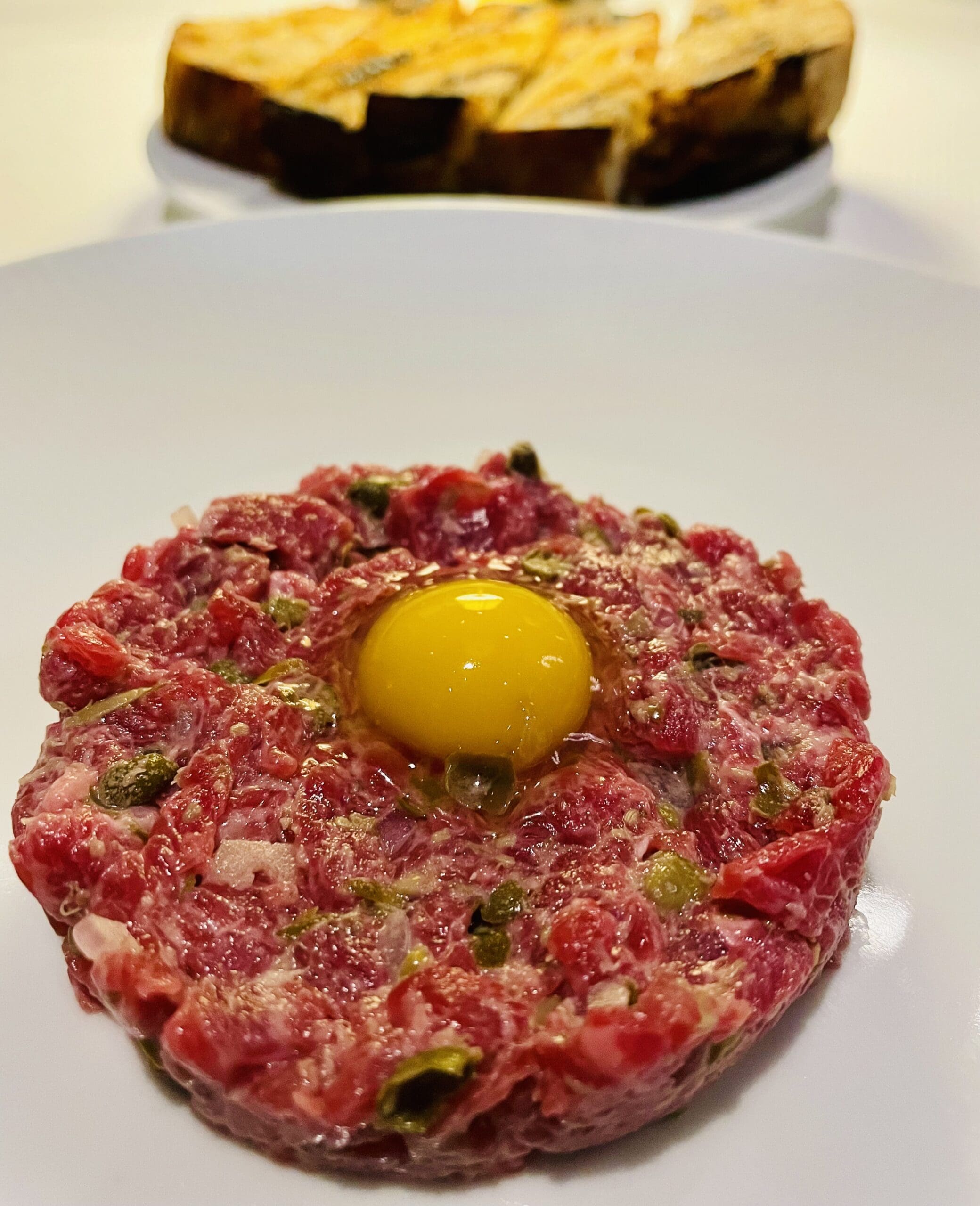 Wagyu beef tartare with shallots, Dijonaise and capers topped with a quail egg are part of The Blue Room at Emilia's menu. (Photo by Courtney Dabney)