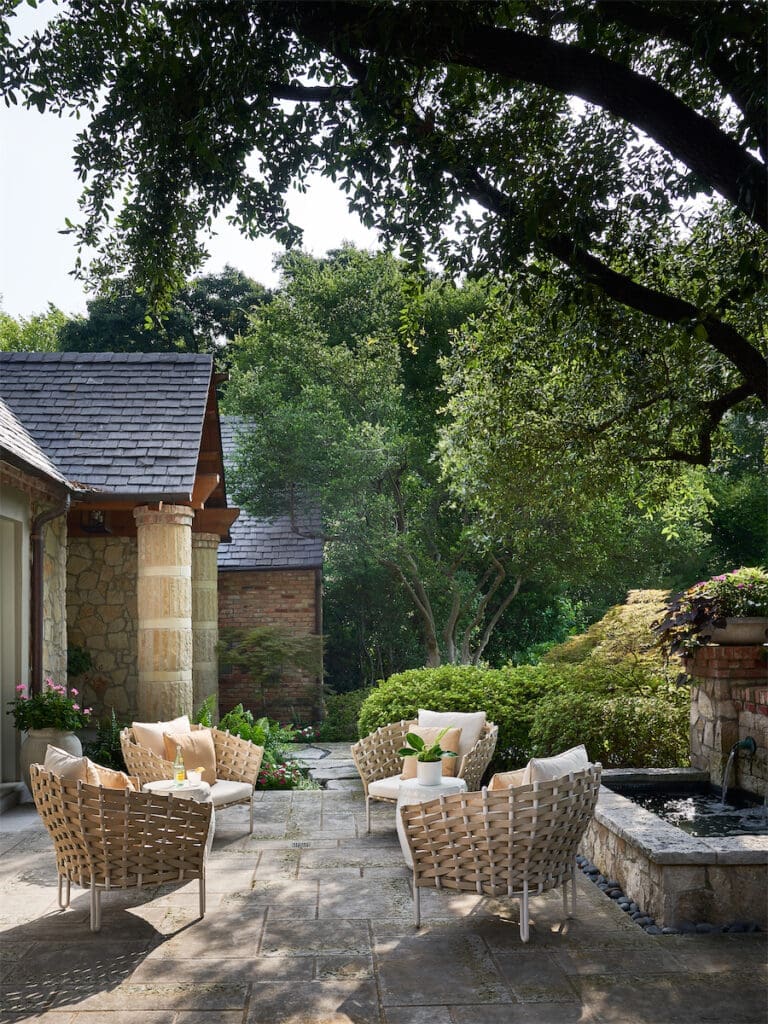 A back terrace features Dilbeck’s signature use of stone, brick, columns, and slate rooftops. (Photo by Stephen Karlisch)