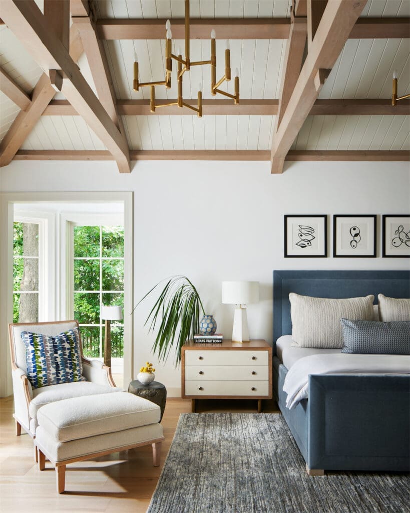 In the main bedroom, custom bed upholstered in Lee Jofa fabric. Baker side table. Restored vintage lounge chair and ottoman. (Photo by Stephen Karlisch)