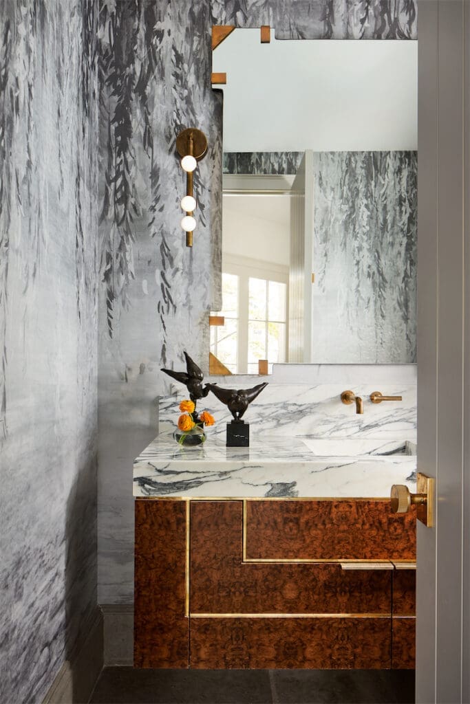 In a powder bath, wallpaper by Phillip Jeffries, Lindsey Adelman sconce, and custom sink. (Photo by Stephen Karlisch)