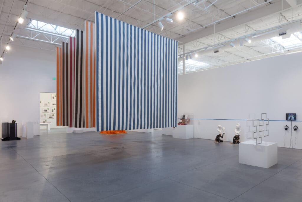 "For What It’s Worth: Value Systems in Art since 1960," The Warehouse, Dallas, installation view with work by Giulio Paolini, Daniel Buren, Andrea Fraser, Roelof Louw, Ivan Moudov, Fred Wilson, Sherrill Roland, Christian Jankowski and Edward Krasinski, Hanne Darboven (background), on view through June 29, 2024 (Photo by Kevin Todora)