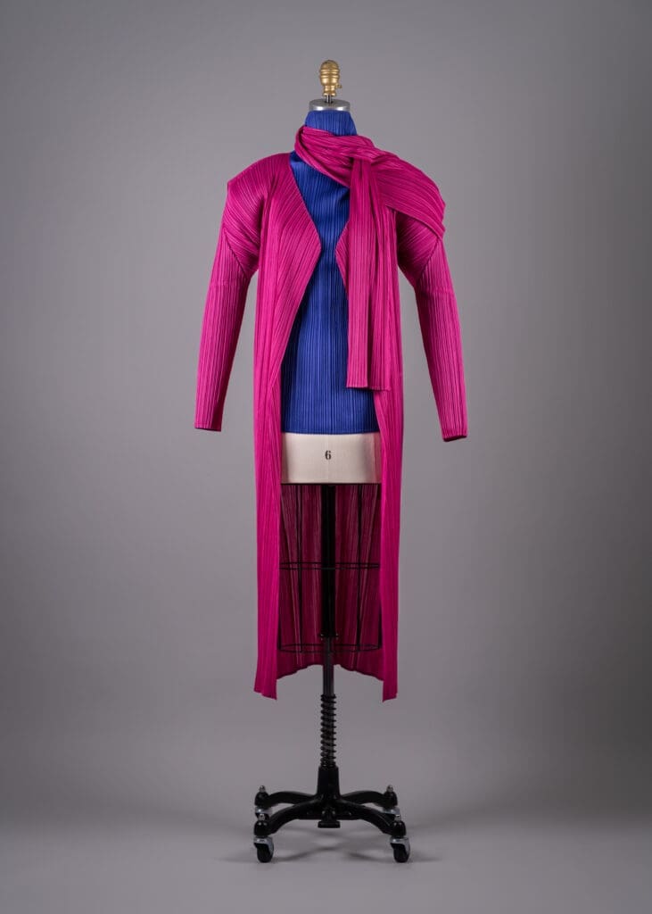 Issey Miyake's blue polyester pleated turtleneck top, Fall 1992, with pink polyester pleated coat and scarf, Fall 2004 (Photo by Shane Quereshi)