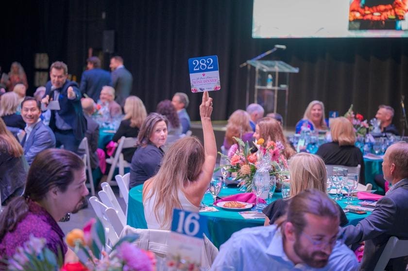 Auctioneer Pat Tully took the crowd at the Pavilion Wine Dinner through spirited bidding on a number special items, including trips and dinner.